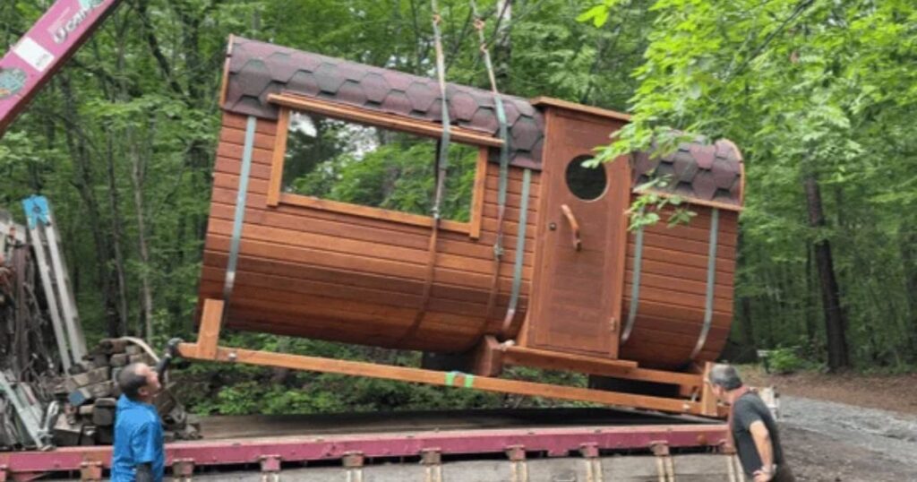 組立済みの大型バレルサウナをクレーンで搬入するようす